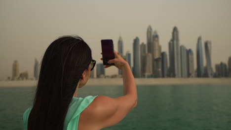 Mädchen-Fotografiert-Die-Skyline-Von-Dubai-Vom-Boot-Aus