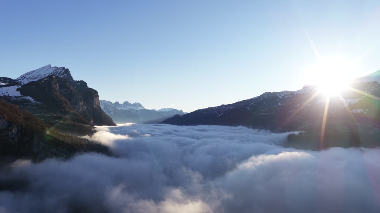 Vista aerea delle vette frastagliate del Churfirsten che emergono da un denso mare di nebbia. Un paesaggio invernale minimalista che mostra il drammatico isolamento delle Alpi svizzere