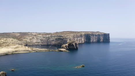 bahía marina de dwerja con yates anclados entre enormes acantilados rocosos, malta