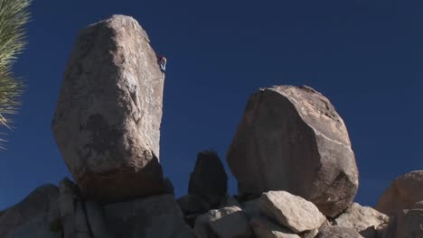 a climber begins to descend a rock face