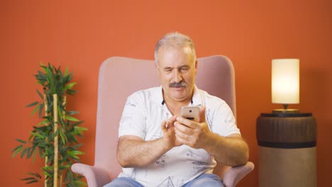 Happy-old-man-texting-on-the-phone.-Smiling.