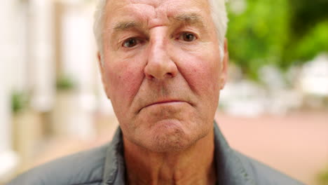 retrato de un hombre mayor serio afuera en un parque