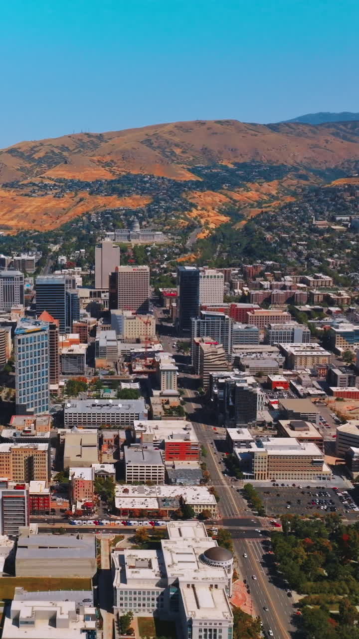 Salt Lake City downtown at sunny daytime. Amazing city scenery at the backdrop of beautiful mountains. Top view. Vertical video