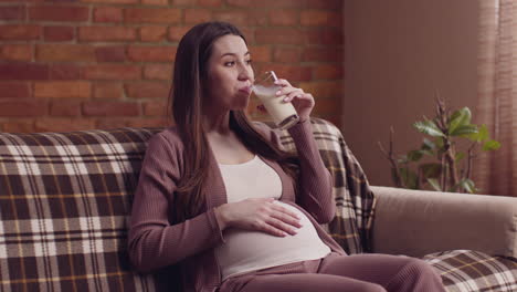 pregnant woman drinking milk at home