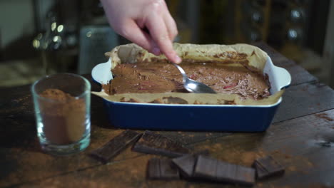 haciendo postre de chocolate. preparando para hornear pastel. hombre mano extender chocolate