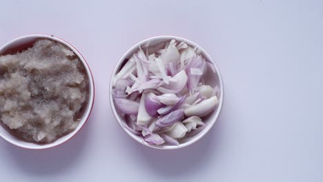 top view of slice of onion and paste in a bowl on white background