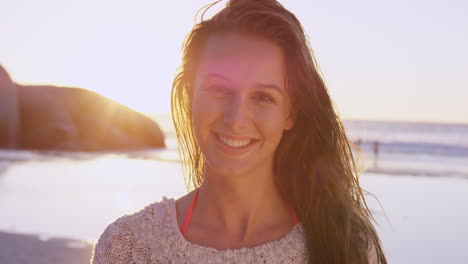 portrait of beautiful girl smiling on beach at sunset in slow motion