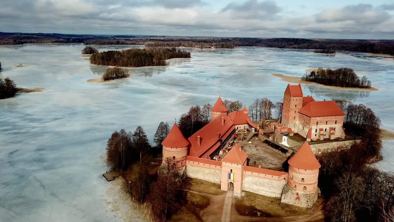 트라카이 카스테 리투아니아, 구름이 많은 날에 얼어붙은 호수에 있는 중세 성의 드론 촬영