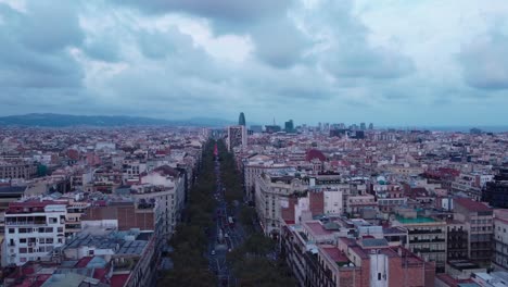 Barcelona-skyline-with-a-cloudy-sky,-showcasing-urban-density-and-architecture,-aerial-view