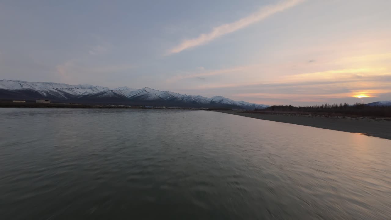 눈 인 산꼭대기 에서 부드럽게 흐르는 강의 숨을 는 아름다움을 목격하십시오. 태양이 색이 넘치는 전시에서 해가 지고, 하늘을 황혼의 색으로 칠합니다.