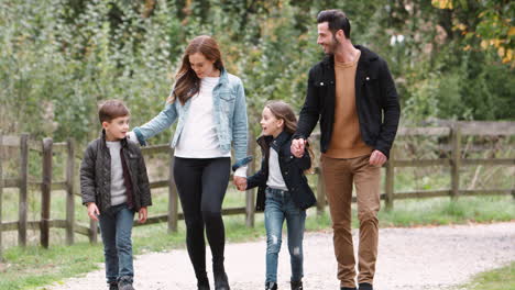 Family-Group-Walking-Along-Path-Through-Autumn-Landscape-Together