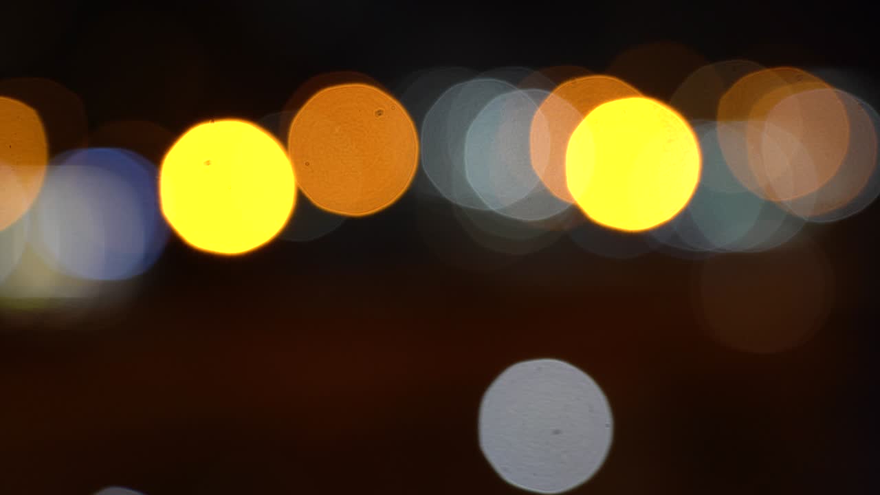 luces de la calle borrosas. círculos de bokeh en movimiento del tráfico nocturno