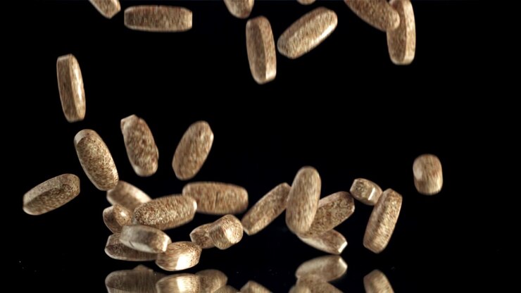 Many Brown Pills Falling and Bouncing on Black Background