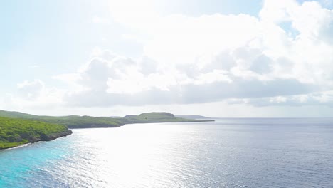 Aerial-pan-follows-frigate-birds-soaring-above-tropical-coastline-oceanic-waters