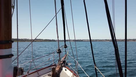 sailboat cruising on big blue lake with land in the distance, slow motion