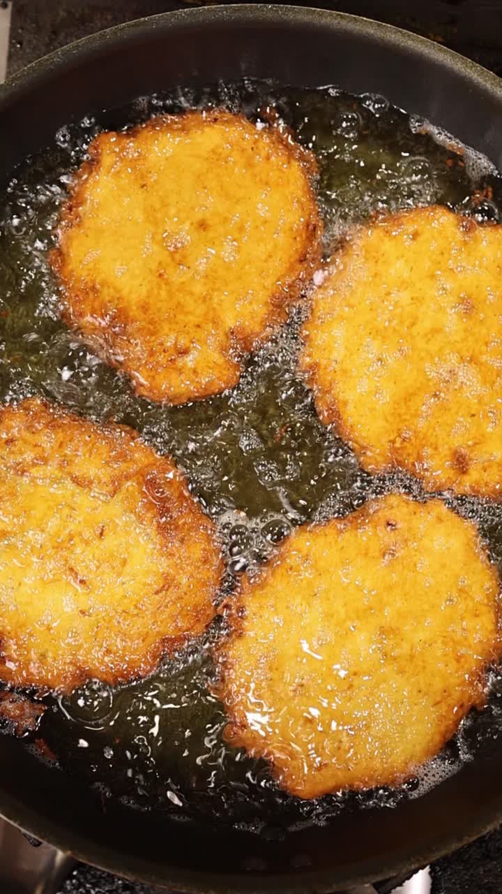 Frittelle di patate dorate che friggono nell'olio caldo