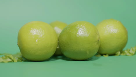 closeup shot of juicy fresh lime fruit on isolated green surface