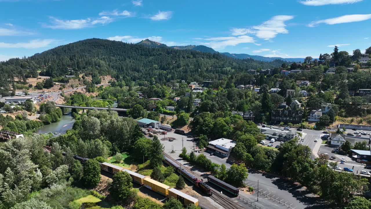 Drone tracking a train driving through the Hood river town, in sunny Oregon, USA