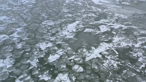 Drone-Volando-Hacia-Atrás-Sobre-Hielo-Sobre-El-Lago-En-El-Viento-Y-El-Frío