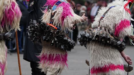 bulgarian kukers in wool costumes dancing in slow motion with heavy bells on the waist and making the wool strands bounce