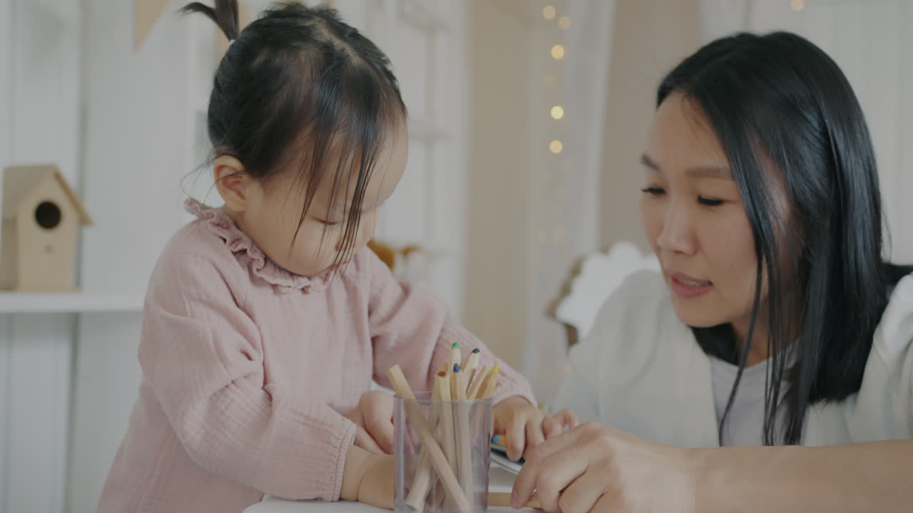 母親と幼児が一緒に塗り絵をする