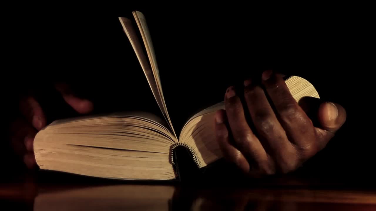 rezando a dios con las manos junto con la biblia y el hombre cruzado del caribe rezando con fondo negro almacen de video