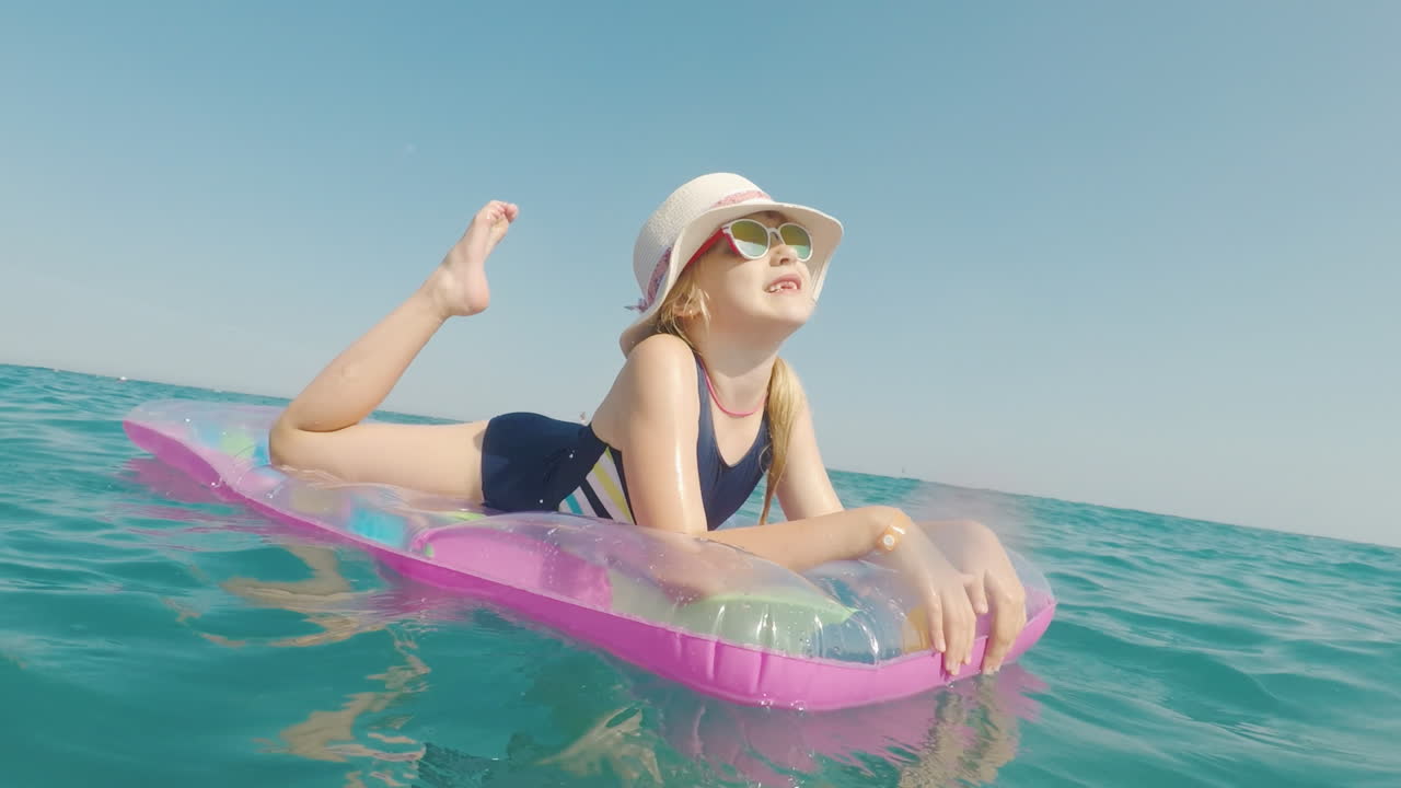 A Girl In A Hat And Sunglasses Floats In The Sea On An Inflatable Mattress Merry Vacation Concept
