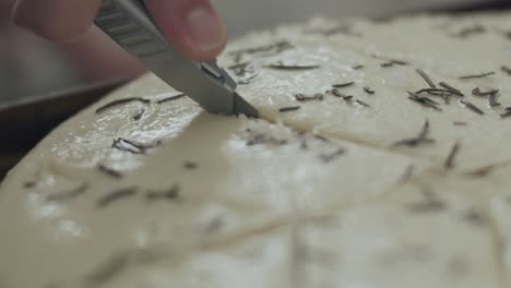 chef making pattern on focaccia dough