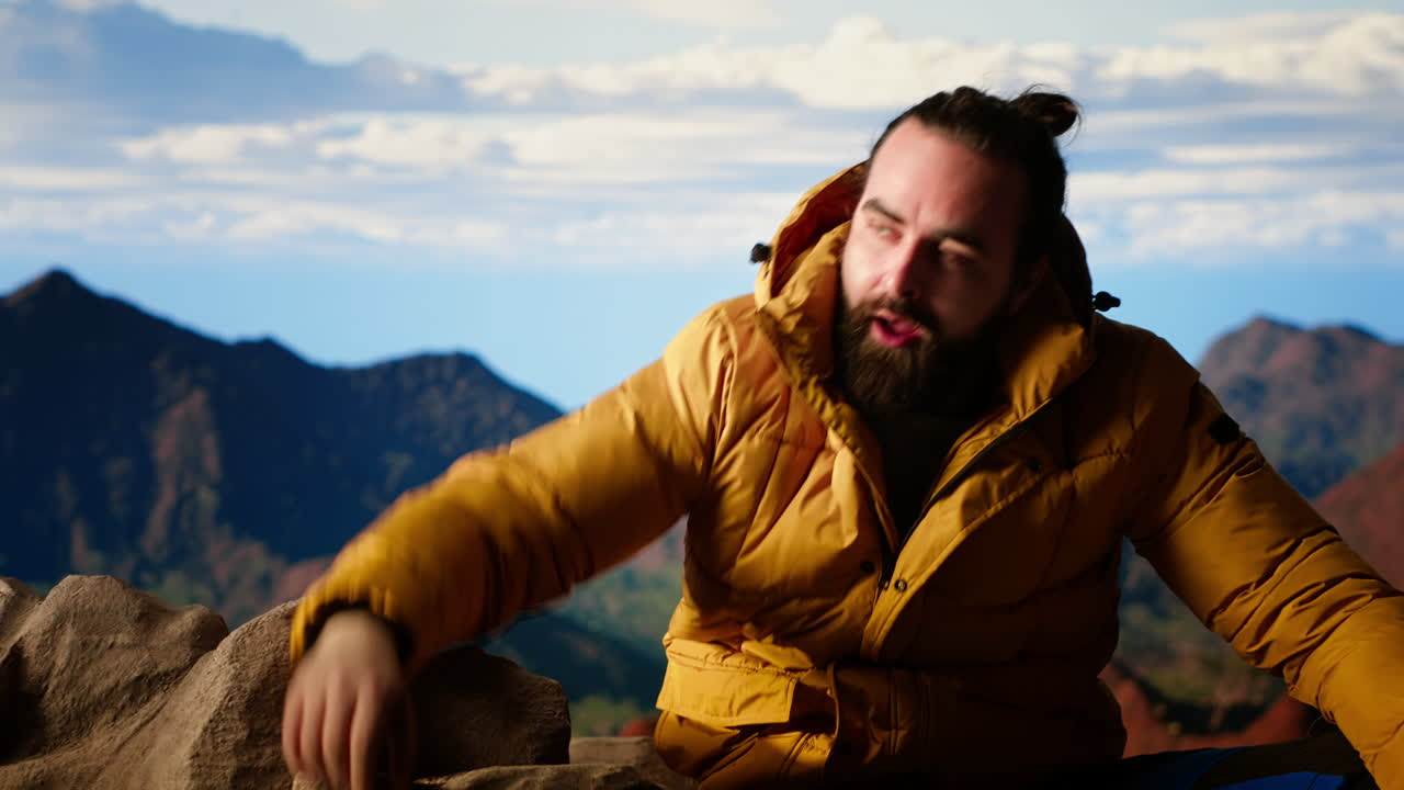joven viajero con ropa cálida llega a la cima con un profundo sentido de satisfacción