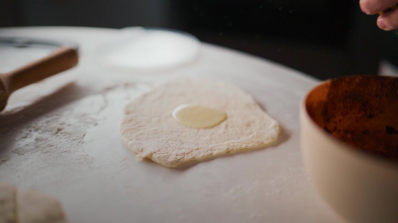 Hands roll dough, pour oil, sprinkle spices. Focus on food prep. Ideal for cooking, recipe, or cultural cuisine clips