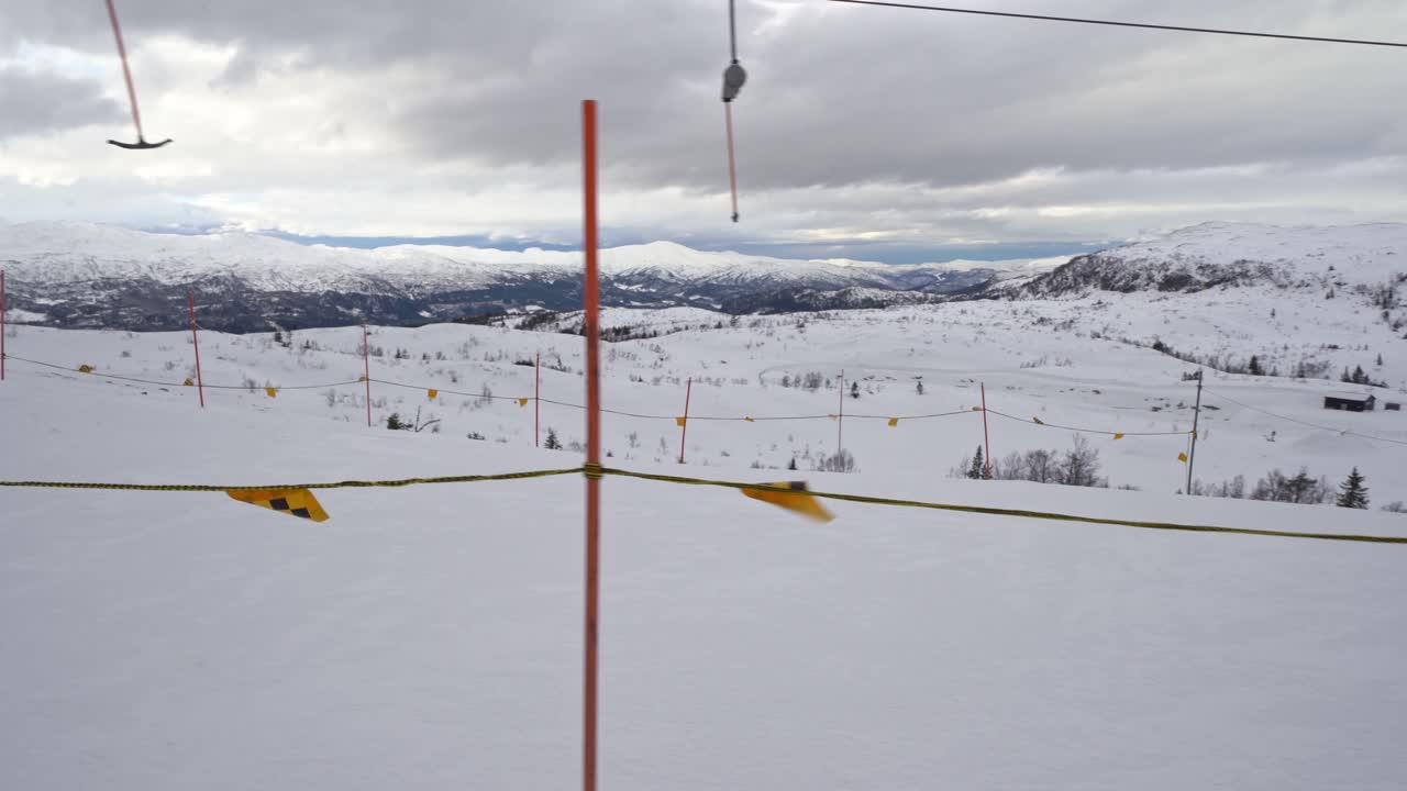 산 정상에서 바람이 많이 부는 날씨에 사람 없이 울타리와 스키 리프트를 옆으로 이동 - 스키 목적지 노르웨이