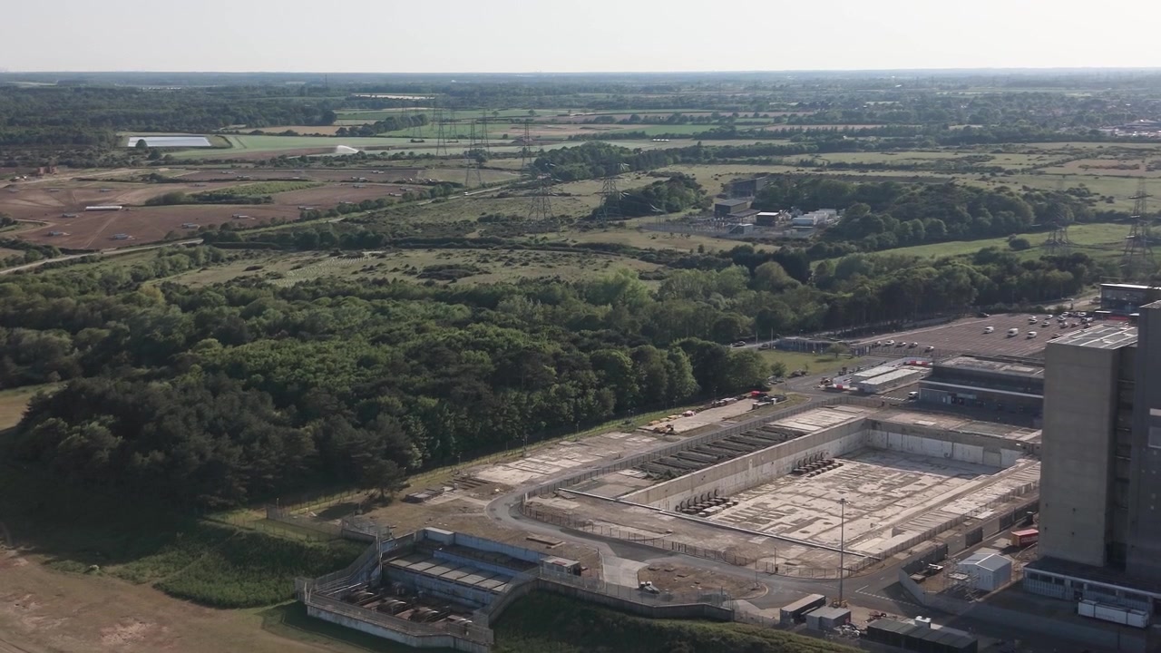 Carrellata aerea con drone su infrastrutture industriali e paesaggio presso la centrale elettrica di Sizewell B nel Suffolk, Inghilterra