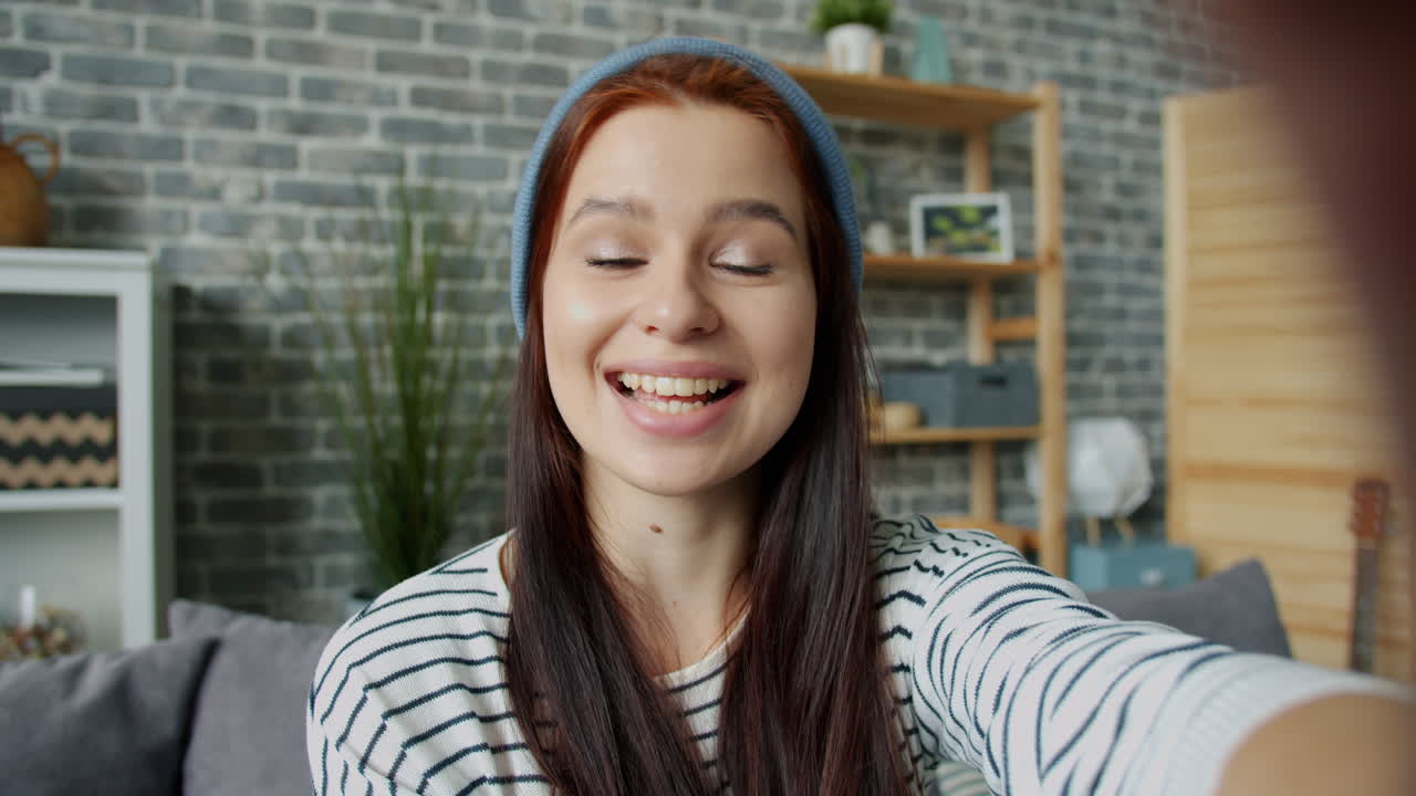 una mujer joven tomando una selfie en casa.