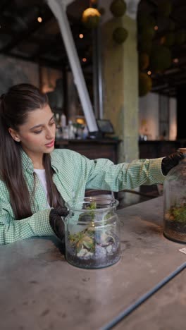 mujer trabajando con terrarios en un café