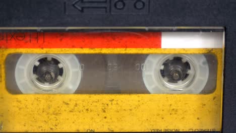 the vintage yellow audio cassette in the tape recorder rotates