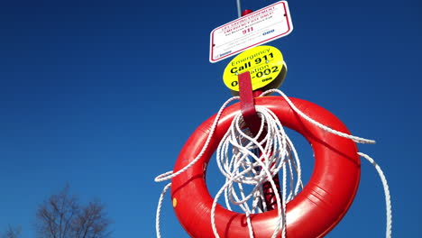 medium shot looking up at a red life preserver set against the blue sky