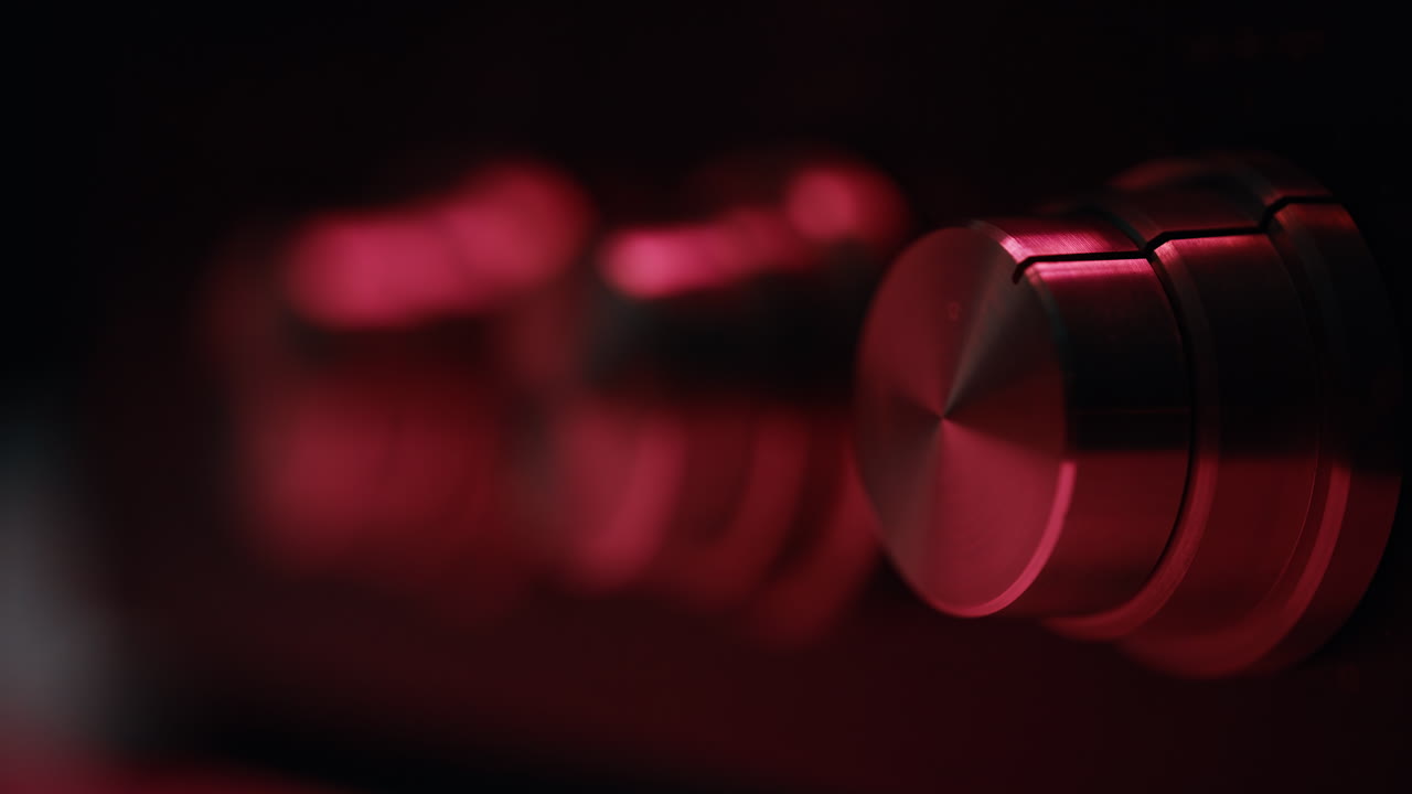 Closeup analog knobs adjusting volume on vintage player indoors. Retro tuner