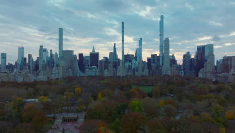 Amplia-Vista-Panorámica-De-Los-Rascacielos-Que-Rodean-El-Parque-Central.-Vuela-Sobre-Los-árboles-De-Color-Otoñal-En-El-Parque-Al-Atardecer.-Manhattan,-Ciudad-De-Nueva-York,-Estados-Unidos