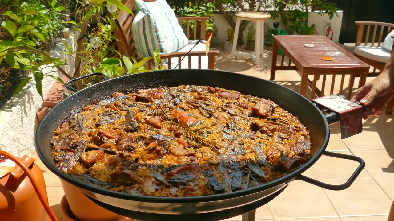 맛있는 발렌시아 파엘라 (valencian paella) 는 스페인의 야외에서 큰 비에서 요리됩니다.