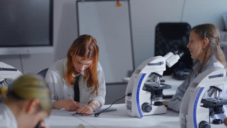 students using microscopes in a science classroom