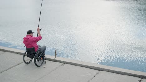 person with a physical disability who uses wheelchair fishing from fishing pier