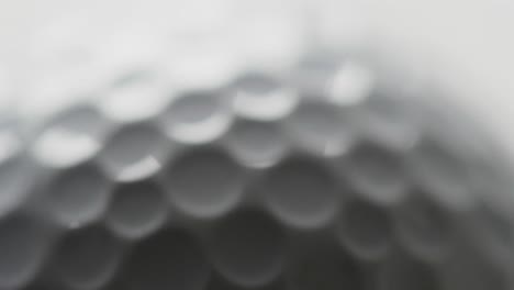 close up of golf ball on white background, slow motion