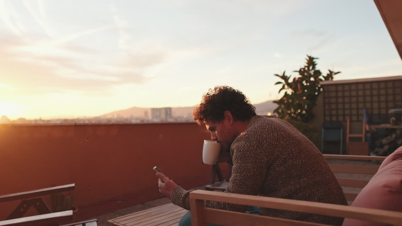 Uomo che beve caffè su una terrazza al tramonto