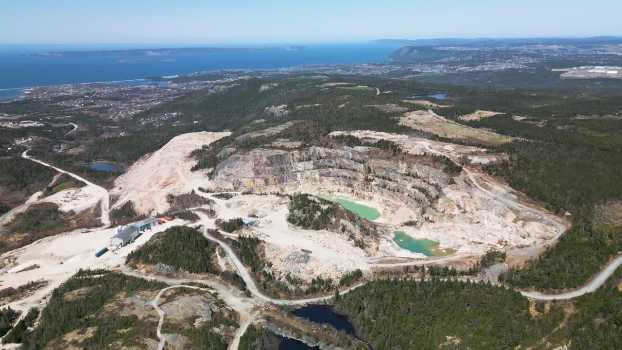 Drone shot of an open talc (pyrophillite) mine in Manuels, Newfoundland, Canada displaying Conception Bay South in the background