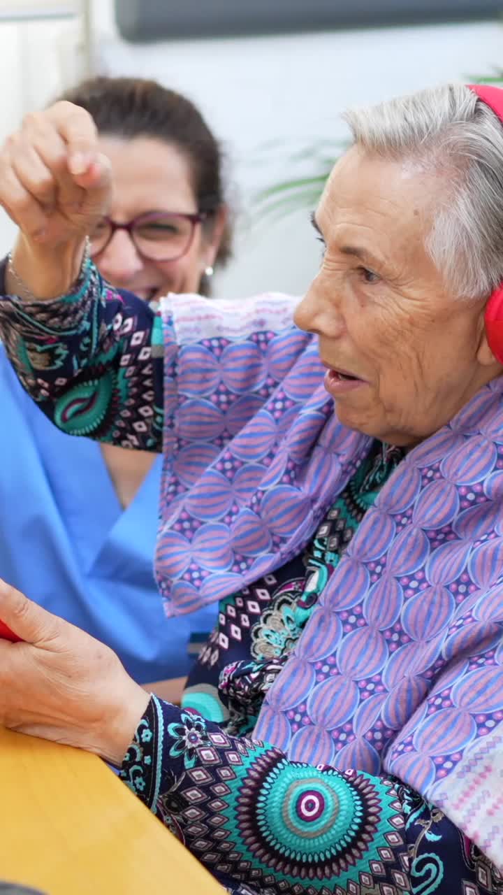 Elderly Woman Interacting with Nurse Using Cellphone