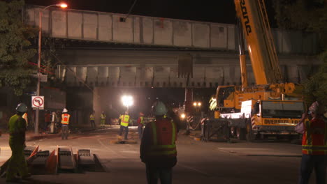 Construcción-workers-work-on-a-freeway-overpass-at-night-in-Los-Angeles