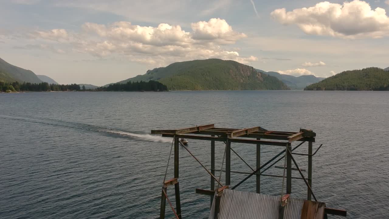 백그라운드에서 제트 스키와 함께 호수에 오래 된 버려진 부두