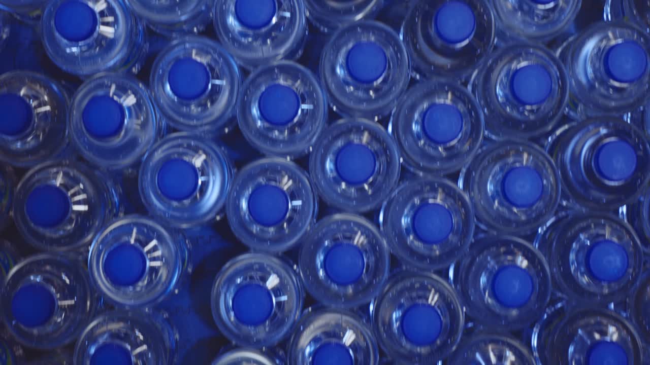 botellas de plástico moviéndose en una cinta transportadora en una fábrica de producción