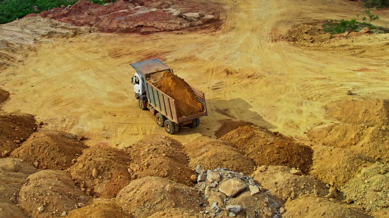 truck driver trying to unload soil in construction area at telangana, india. day time, semi orbit, drone shot. 4k