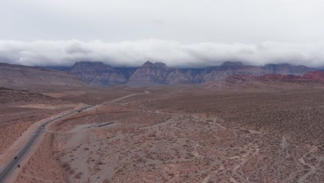 Aerial-wide-rising-and-panning-shot-of-Red-Rock-Canyon-on-a-moody-cloudy-day-in-Las-Vegas,-Nevada